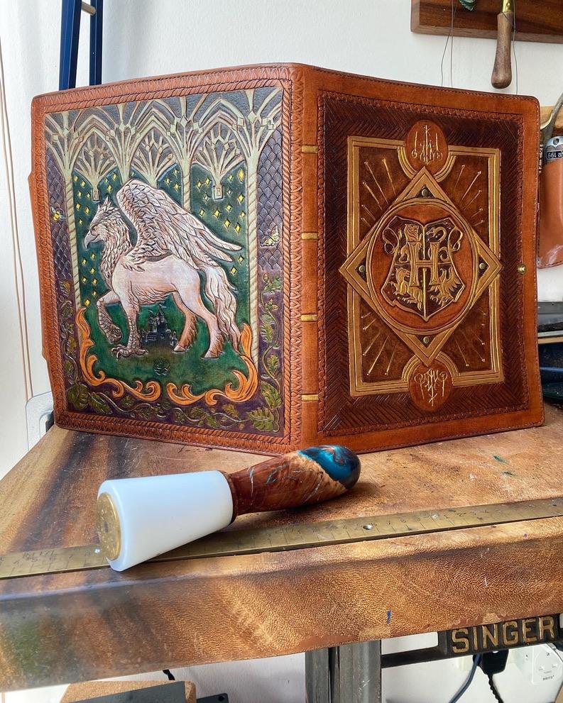 A fantastical iPad cover, inspired by the Wizarding World of Hogwarts Legacy Game. The Hogwarts House is carved on the front and painted shades of brown and gold, and the back features a Hippogriff standing watch under a vaulted ceiling of stars.