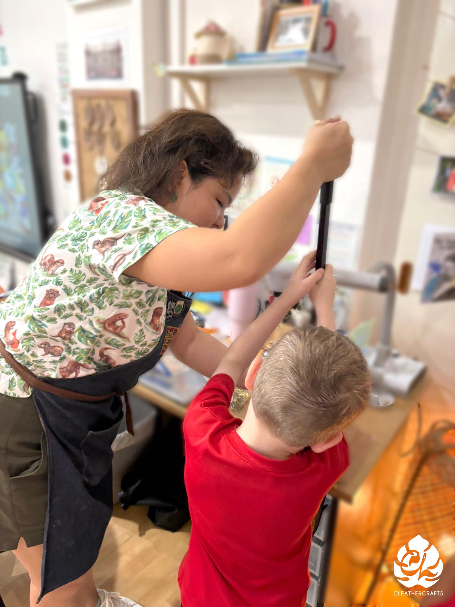 With my guidance, we set the rivets together. The machine handle was out of reach for the children by itself, so it required an adult's help.