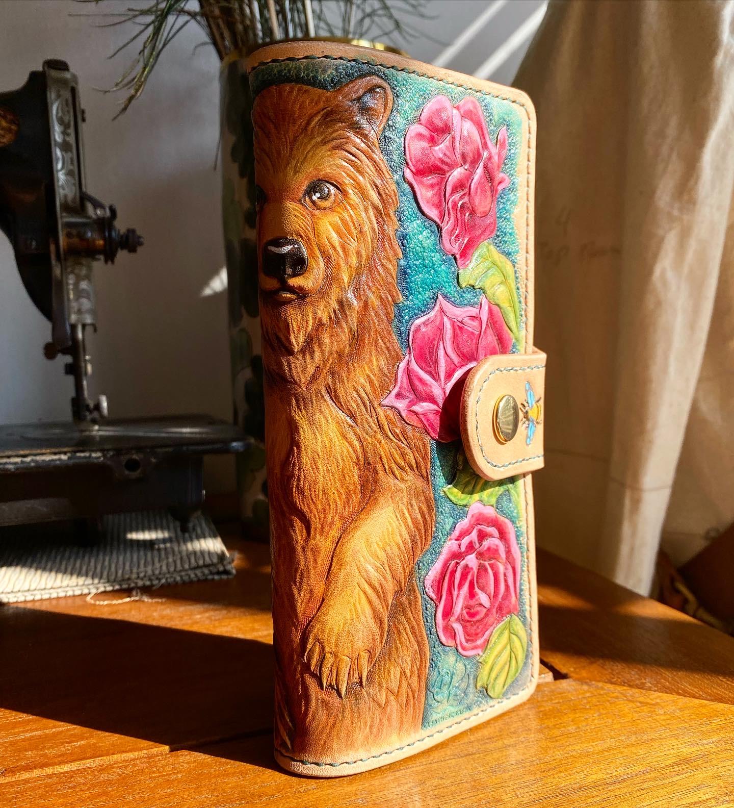 A long wallet featuring a standing mother bear, surrounded by a forest of roses in bloom.