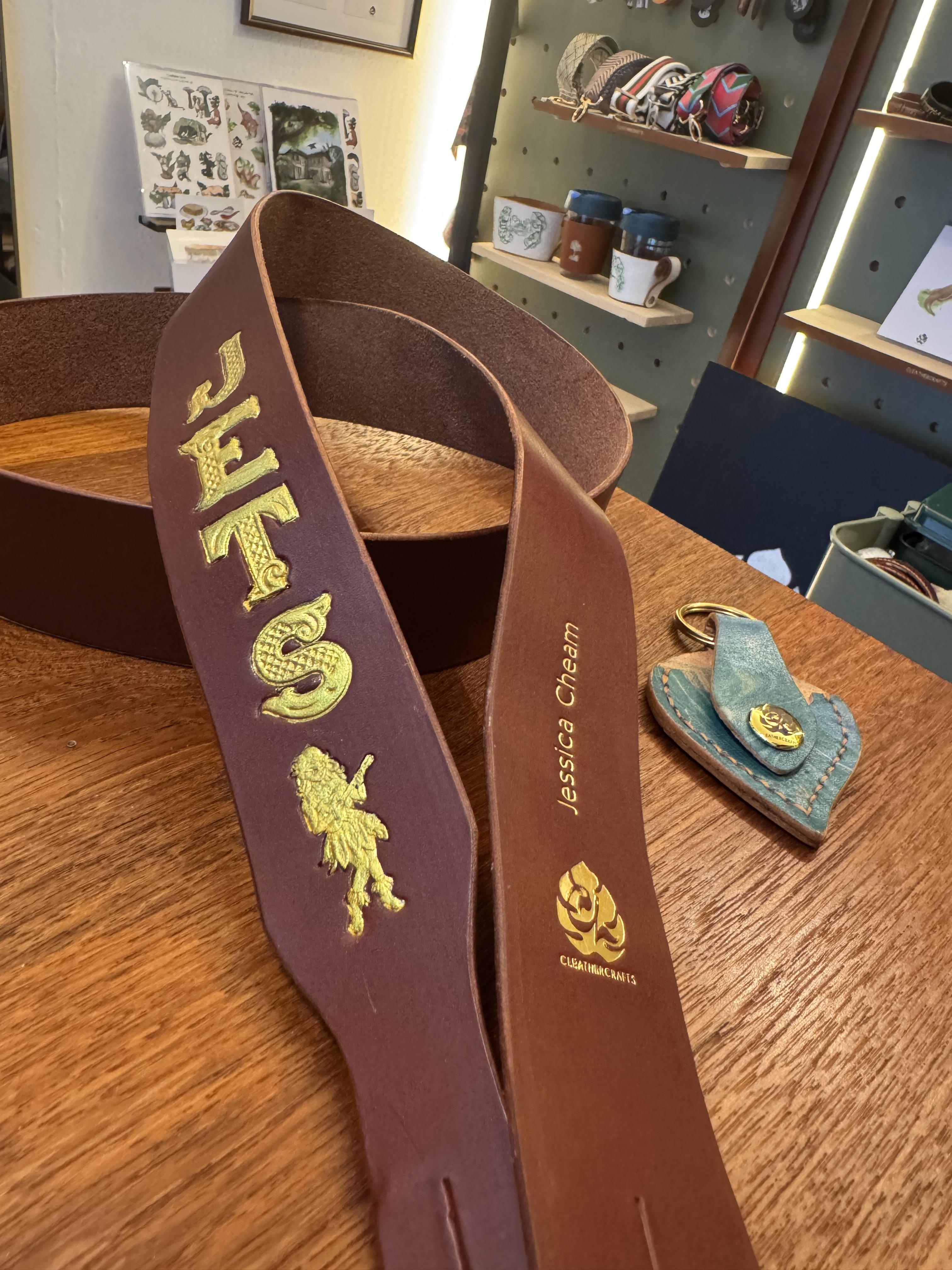A custom ukulele strap made as a birthday gift for an amazing musician. Hand stamped with the band name and painted gold on supple Italian veg tan leather in Chestnut brown.